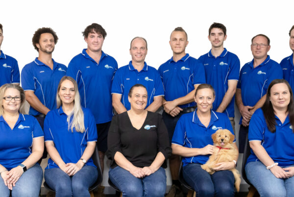 Technician finishing an outdoor lighting installation Kippa Ring, placing low voltage spike lights along a garden path.