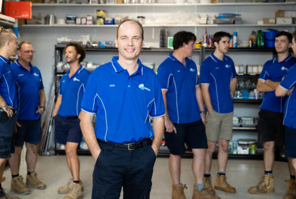 Technician testing an element and thermostat during a hot water system electrician North Lakes callout at an outdoor tank.